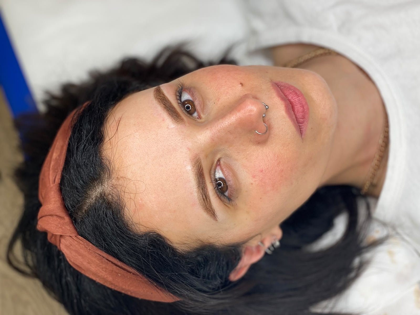 Dettaglio viso con sopracciglia definite e piercing naso