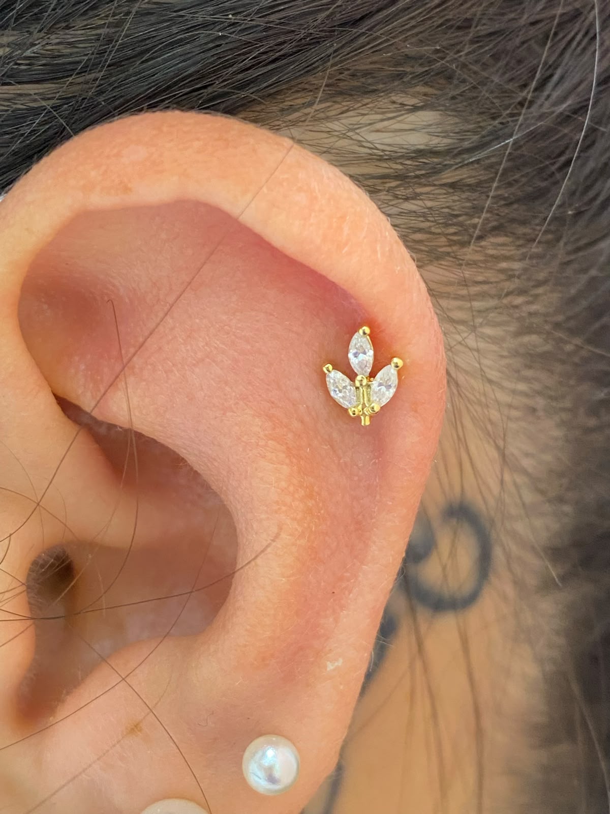 Dettaglio piercing helix a fiore in oro